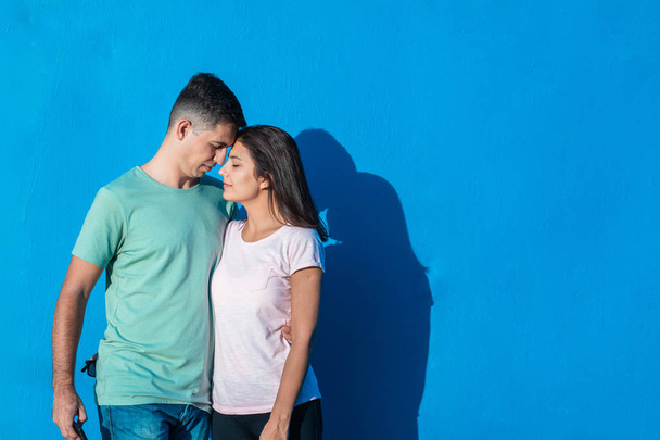Νεαρό ζευγάρι που χαμογελάει και στέκεται μαζί απομονωμένος σε μπλε φόντο. Αντίληψη των ανθρώπων και των συναισθημάτων με χώρο αντιγραφής. - Φωτογραφία, εικόνα