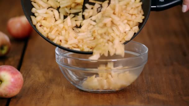 Woman puts Apple Cinnamon Pie Filling in the glass bowl. - Video