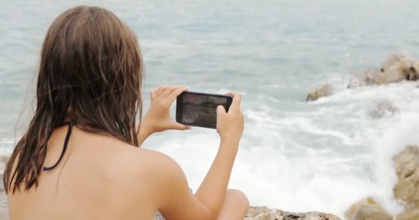 Girl Photographing Storming Sea on Smartphone - Кадры, видео