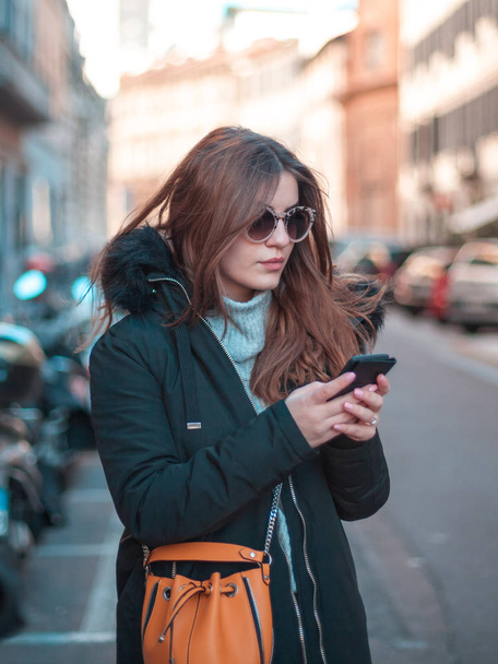 Milano sokaklarında güneş gözlüğü ve telefon güzel kız.  - Fotoğraf, Görsel
