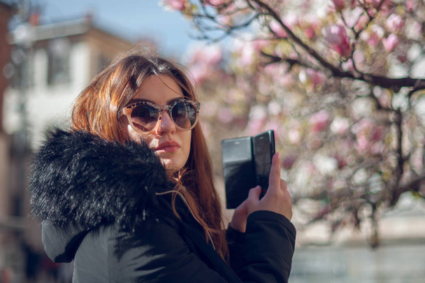 Mooi meisje in zonnebril en telefoon op de straten van Milaan.  - Foto, afbeelding