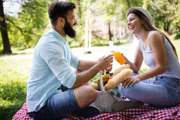 Happy couple in love enjoying picnic time outdoors - Foto, afbeelding