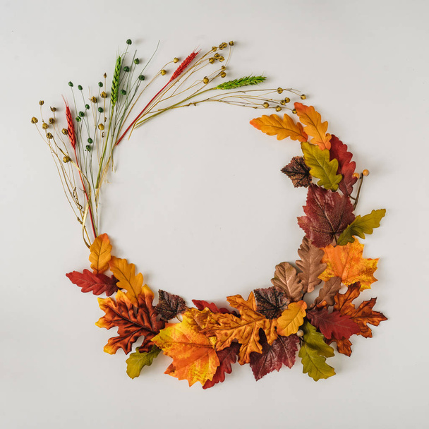 Kreatív szezon elrendezése színes őszi levelek és ágak formájában koszorú. Szezonális koncepció.  - Fotó, kép