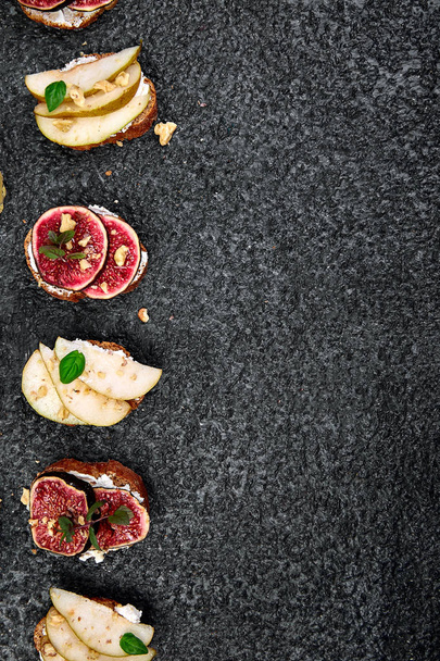 Bruschetta and Crostini with pear, ricotta cheese, honey, figs, nuts and herbs. Breakfast toasts or snack sandwiches. Antipasto. Italian food. Top view. Copy space. - Foto, immagini