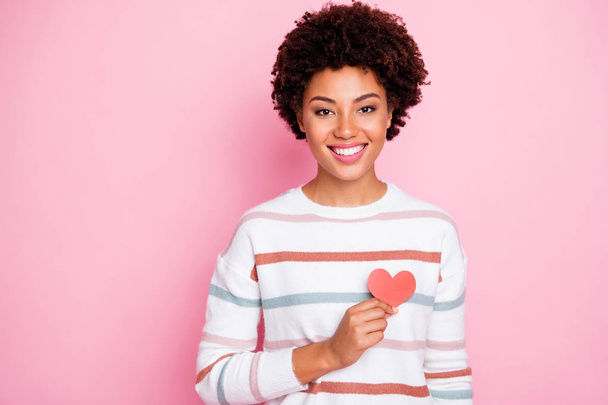 Photo of toothy fascinating cute charming nice black youngster showing her love heart red shape smiling beaming wearing white striped sweater isolated over pink pastel color background - Φωτογραφία, εικόνα