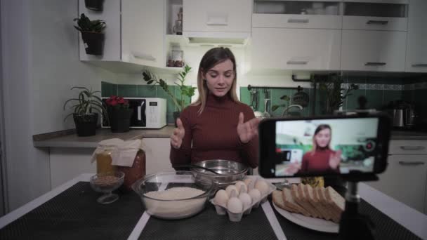 fashion blogger, cute housewife writes recipes for her blog on a social network to her phone and shows products on camera - Video, Çekim