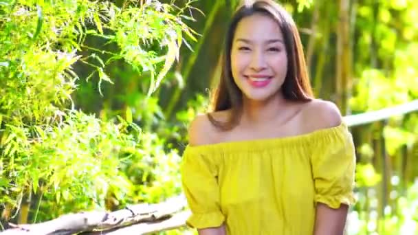 zdjęcia pięknej Azjatki w żółtej sukience patrząc na aparat - Materiał filmowy, wideo