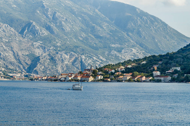The city on the beach at the foot of the high mountains in the Bay of Kotor  - Fotoğraf, Görsel