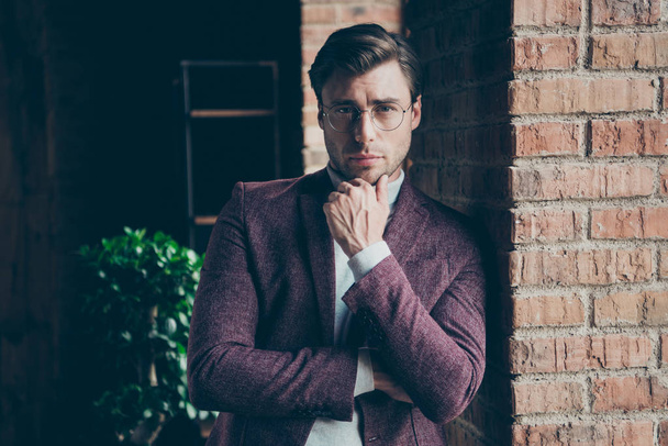 Photo of classy macho business guy looking clever eyes on camera holding hand on chin wear stylish blazer turtleneck leaning wall window modern office room - Photo, Image