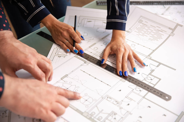 Close up with the hands of two architects who check something in a house plan - Photo, image