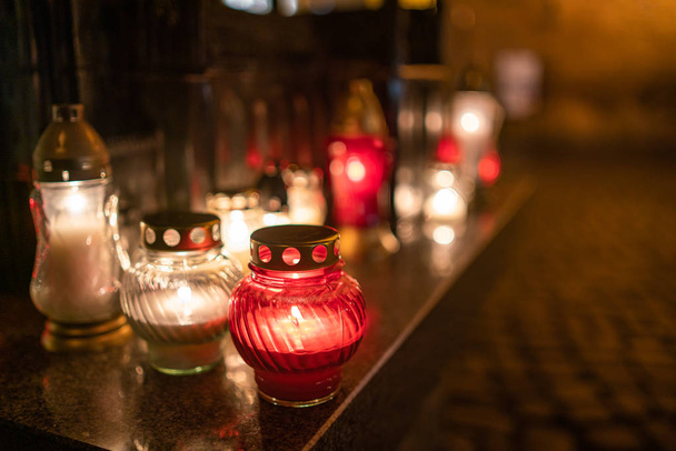 Jars with burning candles on stone surface at night - Photo, Image