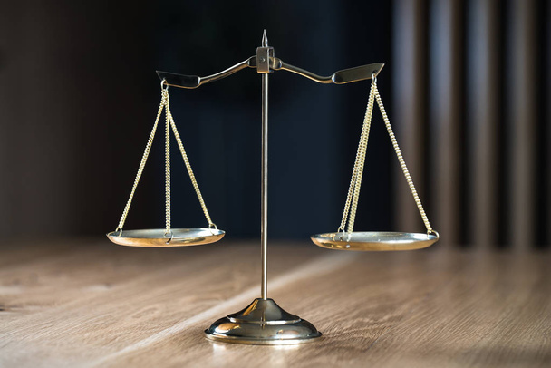 Νόμος και Δικαιοσύνη, κλίμακες σε ξύλινο τραπέζι με θολή φόντο. - Φωτογραφία, εικόνα