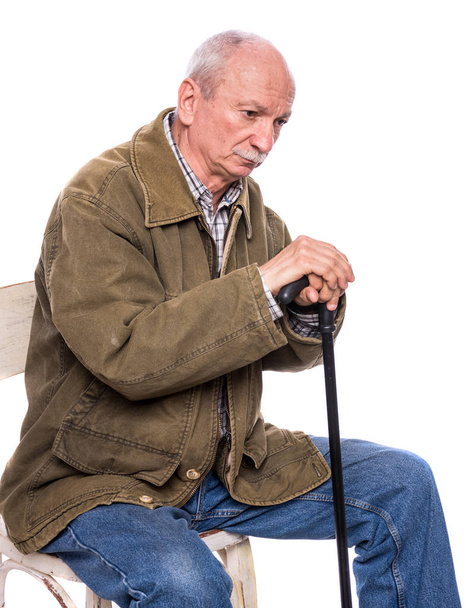 Sad lonely elderly man with a cane sitting  on a chair - Fotoğraf, Görsel