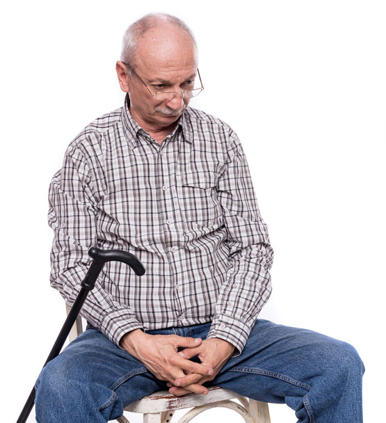 Triste homem idoso solitário com uma bengala sentada em uma cadeira
 - Foto, Imagem