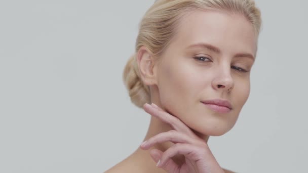 Studio portrait of young, beautiful and natural blond woman applying skin care cream. Face lifting, cosmetics and make-up. - Metraje, vídeo