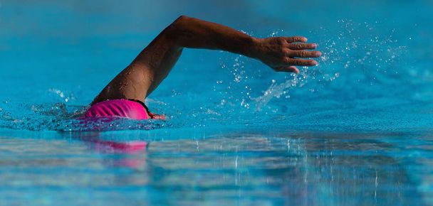 Natación competición nadador atleta haciendo golpe de arrastre en la piscina
 - Foto, Imagen