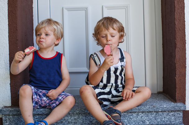 Two little sibling boys eating ice cream - Photo, Image