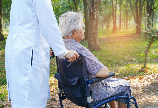 Lääkäri apua ja hoitoa Aasian vanhempi tai vanhusten vanha nainen nainen potilas istuu pyörätuolilla hoitotyön sairaalassa: terve vahva lääketieteellinen käsite
 - Valokuva, kuva