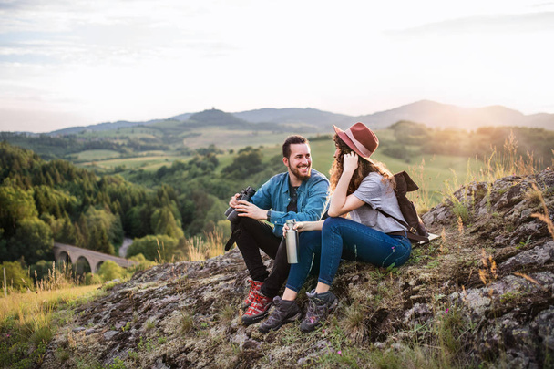 Young tourist couple travellers with binoculars hiking in nature, resting. - Valokuva, kuva