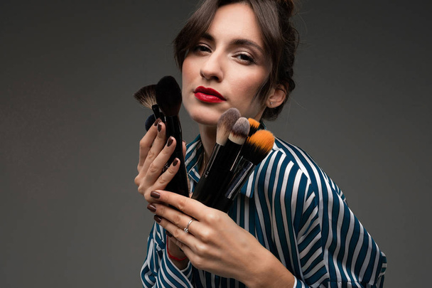 jovem mulher bonita com maquiagem escovas
 - Foto, Imagem