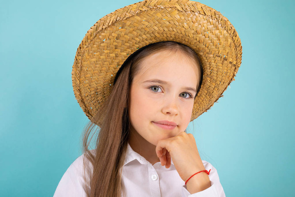 cute little girl wearing straw hat posing in studio  - Foto, afbeelding