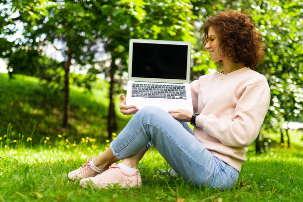 lány dolgozik laptop szabadban ül a füvön  - Fotó, kép