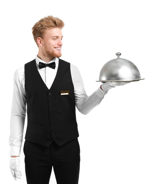 Camarero guapo con bandeja y cloche sobre fondo blanco
 - Foto, Imagen