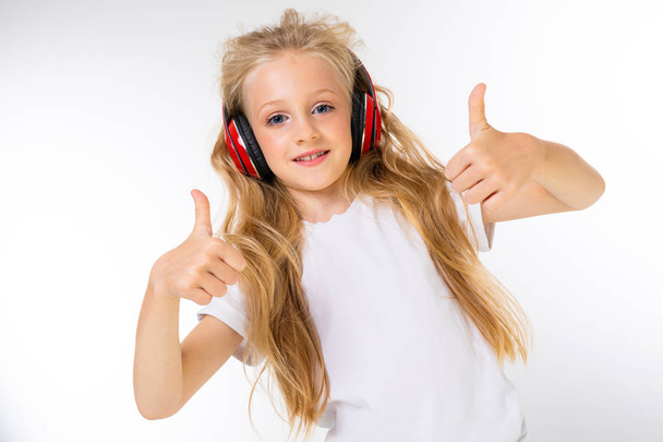 cute little girl listening to music posing in studio  - Фото, изображение