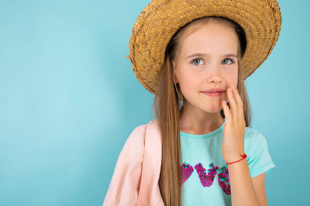 милая маленькая девочка в соломенной шляпе позирует в студии
  - Фото, изображение
