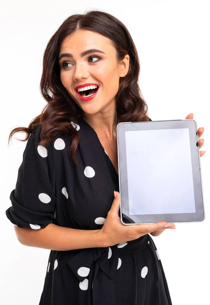 Femme en robe posant avec tablette numérique sur fond blanc
  - Photo, image