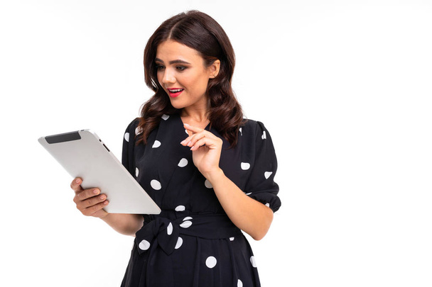 Frau im Kleid posiert mit digitalem Tablet vor weißem Hintergrund  - Foto, Bild
