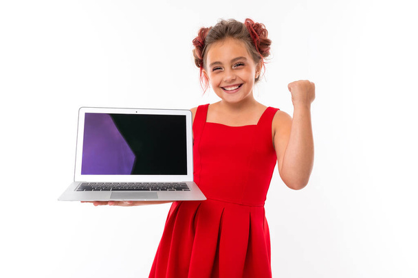 счастливая маленькая девочка с ноутбуком, изолированным на белом  - Фото, изображение