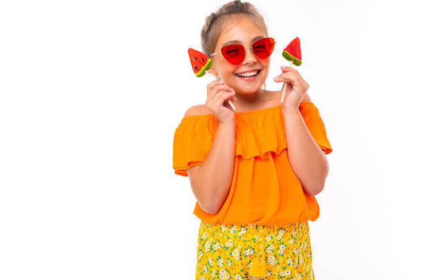 schattig klein meisje poseren met fruit tegen witte achtergrond   - Foto, afbeelding