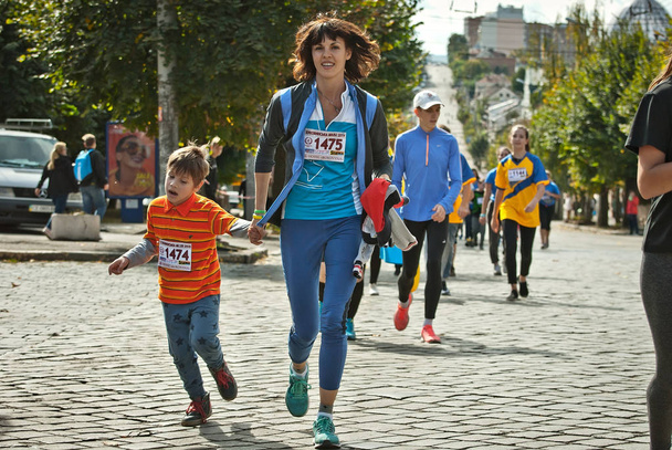CHERNIVTSI, UCRANIA 29 DE SEPTIEMBRE. 2019: Los corredores que participan en la carrera de caridad "Bukovina Mile". Una corta carrera maratónica para apoyar la paz. Deportes para familias y un estilo de vida saludable
. - Foto, Imagen