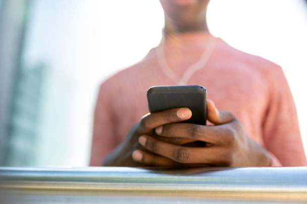 Zbliżenie portret African American mężczyzna ręce trzymając telefon komórkowy - Zdjęcie, obraz