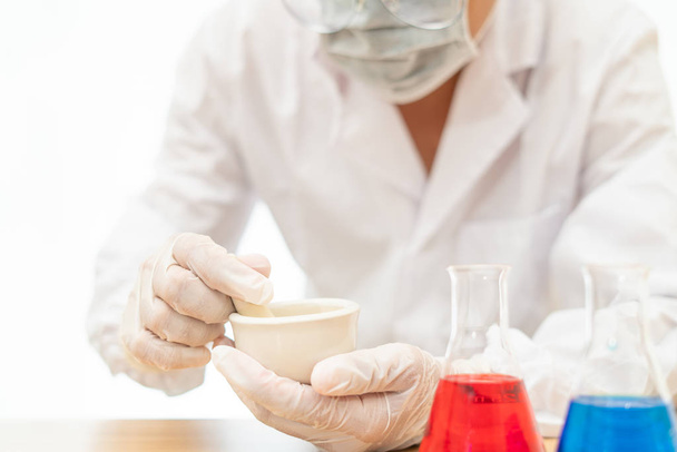 Científicos moliendo medicina en un laboratorio sobre fondo blanco
, - Foto, imagen