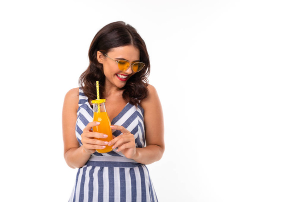 beautiful brunette girl drinking juice posing in studio  - Photo, image