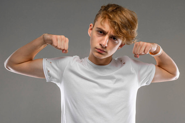 schöner emotionaler Teenager-Junge posiert im Studio gegen Grau - Foto, Bild