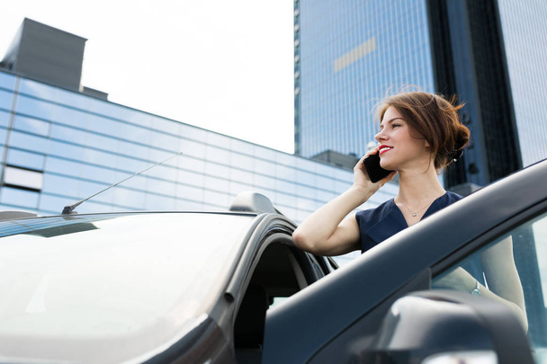 beautiful woman talking on the phone near car  - Foto, Imagem
