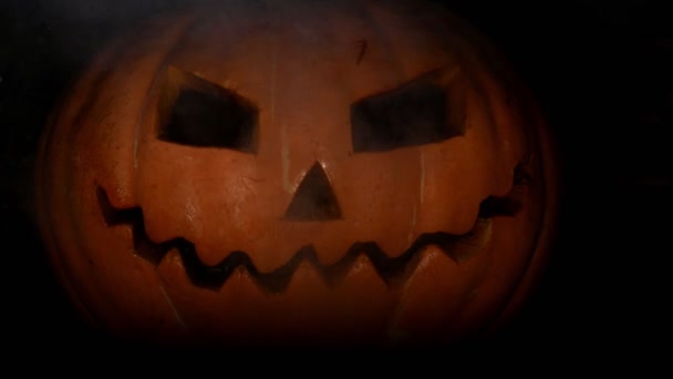 Spooky pumpkin jack-o-lantern face with fire in the eye of darkness. 4k. Halloween concept. Crazy and terrible facial expression. - Footage, Video
