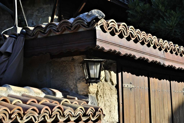 Old door rusty lamp vintage rustic elements wooden exterior ancient entrance sunny day  - Photo, Image