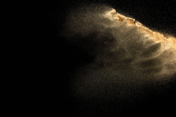 Bruine droge rivierzand explosie geïsoleerd op zwarte achtergrond. Abstract zand splash. - Foto, afbeelding