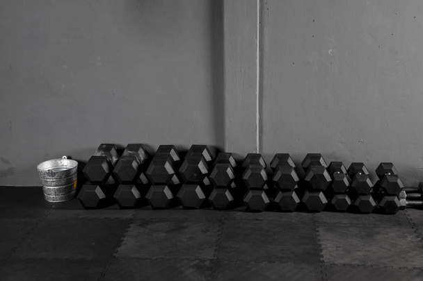 Dumbbells de crossfit de varios pesos con fondo gris sobre piso de goma de un Box  - Photo, Image