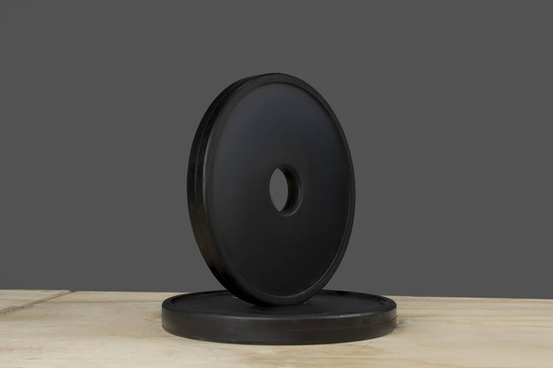 Discos de crossfit para levantamiento sobre una caja de madera con fablo gris
 - Фото, изображение