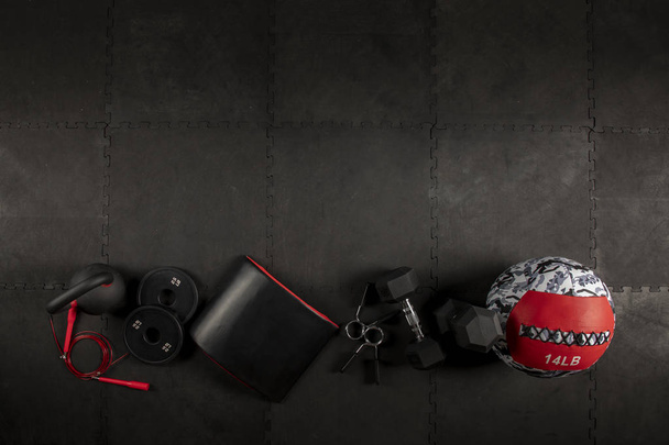 Dumbbell, Cuerda, kettlebell, cojin, pelota y disco's para hacer ejercicios de CrossFit y fitness en Piso de Fondo Color Negro - Foto, afbeelding