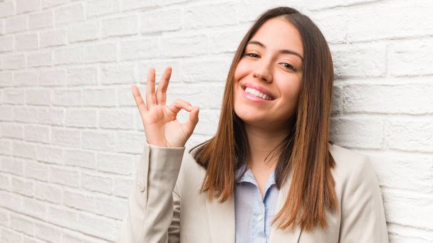 Młoda kobieta biznesu wesoły i pewny siebie robi OK gest - Zdjęcie, obraz