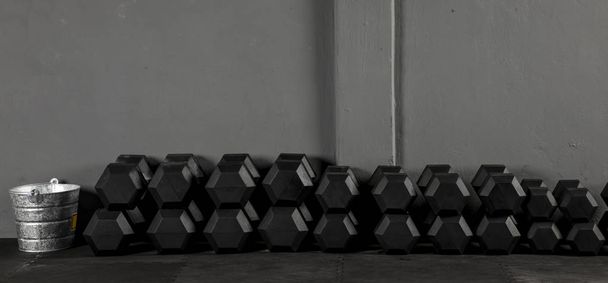 Dumbbells de crossfit de varios pesos con fondo gris sobre piso de goma de un Box  - Photo, Image
