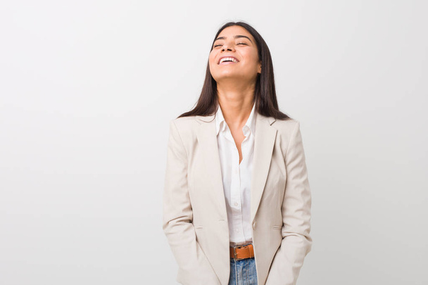 Fiatal üzleti Arab nő izolált fehér háttér nyugodt és boldog nevetve, nyak kinyújtott mutató fogak. - Fotó, kép