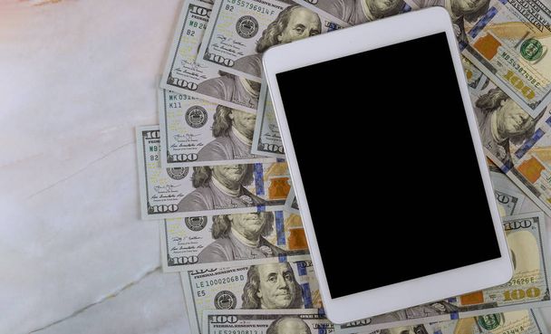 American banknotes hundred dollar bills on digital devices tablet with e-commerce concept - Foto, imagen