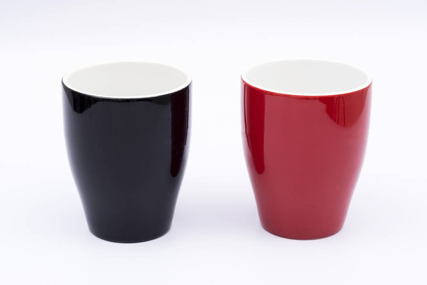 taza negra y taza roja con fondo blanco - Foto, Imagen